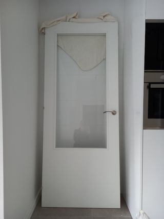 Puerta maciza cocina blanca con cristal.