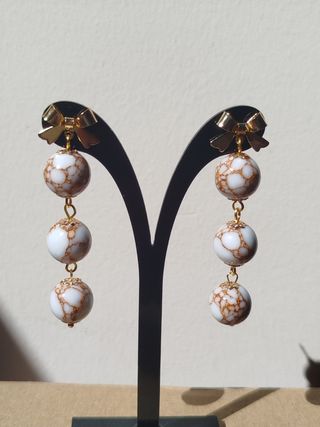 Pendientes lazo dorados con bolitas blancas