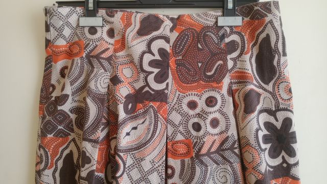 Falda plisada marrón-naranja.