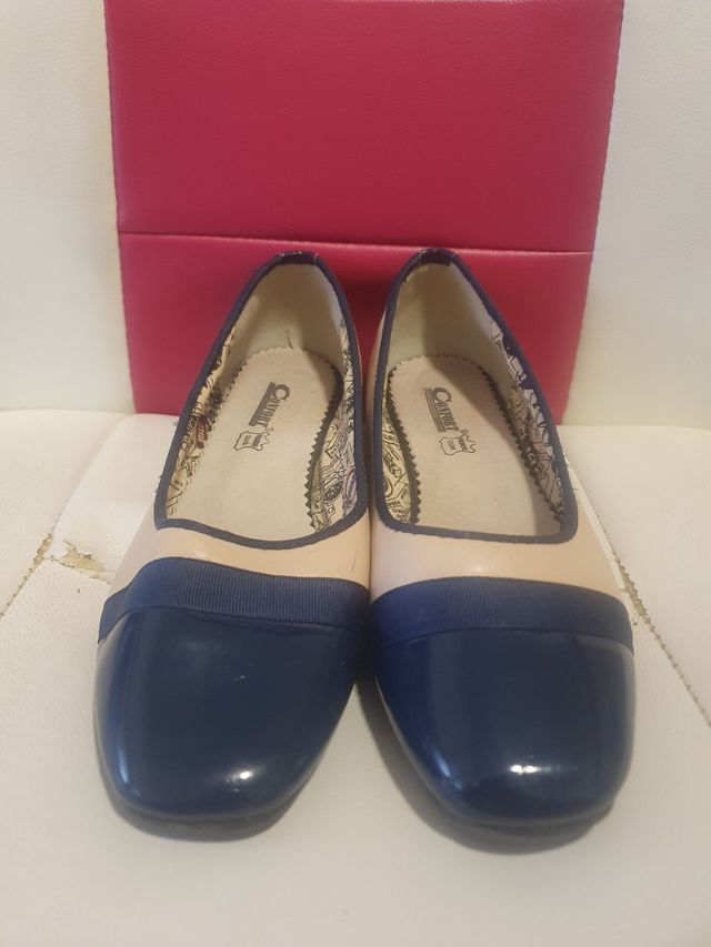 Zapatos planos color beige y azul marino.