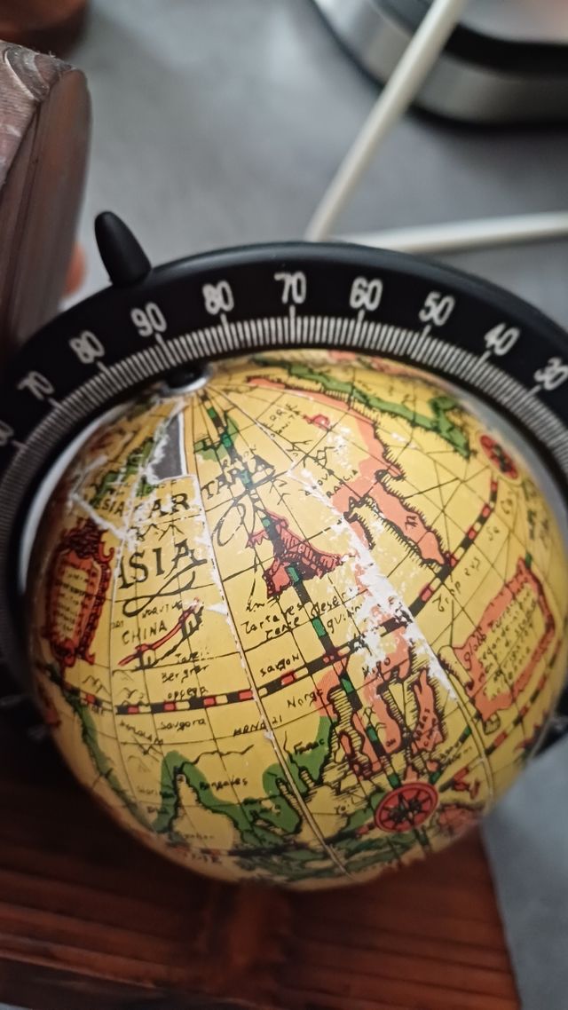 Sujeta libros globo terráqueo vintage