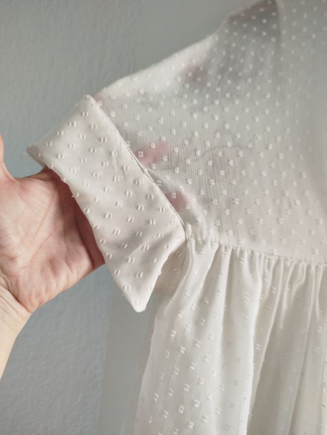 Vestido corto en color crudo con pantalón .