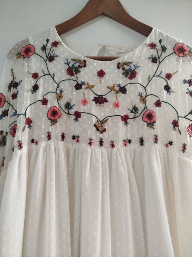 Vestido corto en color crudo con pantalón .