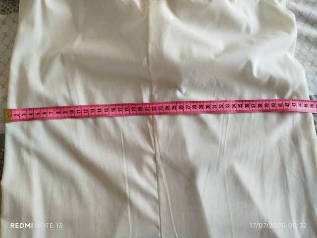 Vestido corto en color crudo con pantalón .