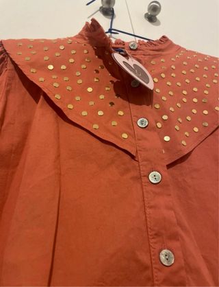 Camisa anaranjada con tachas doradas