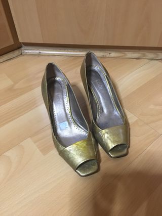 Zapatos Lodi dorados de tacón. El tacon mide 7 cm