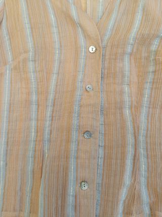 Blusa semi-transparente con rayas azul y rosa.