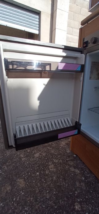 Cocina caravana: nevera, gas y fregadero. Mesas