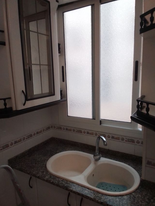 Muebles cocina blanco-negro.Es muy grande y lineal