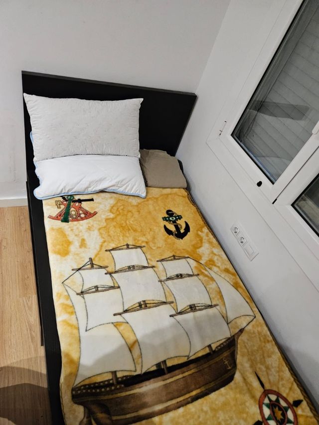 Cama individual con cajones color negro.