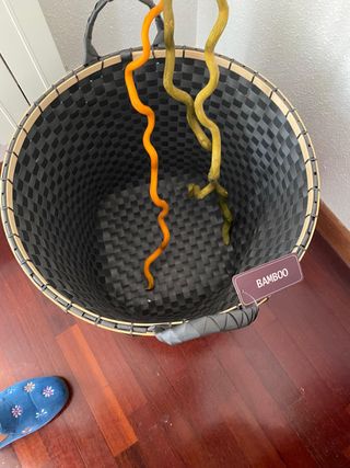 Cesto decorativo gris con ramas de ratán de colore