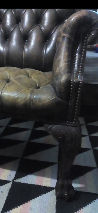 Butaca orejera con patas de garra capitoné cuero.