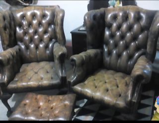 Butaca orejera con patas de garra capitoné cuero.