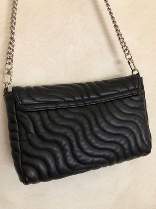 Bolso negro acolchado.
