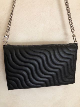 Bolso negro acolchado.
