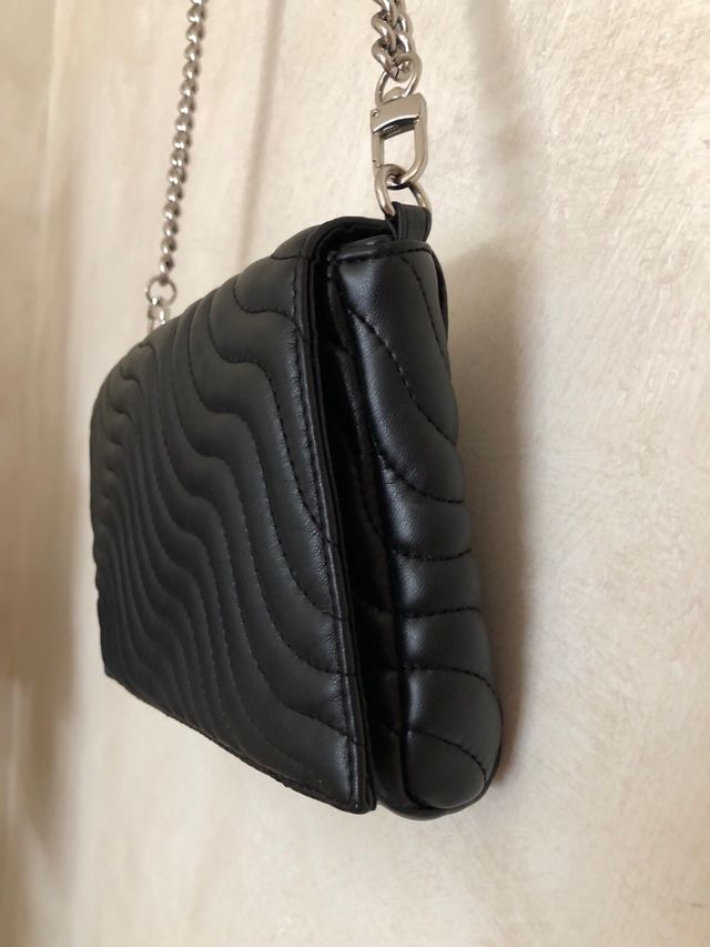 Bolso negro acolchado.
