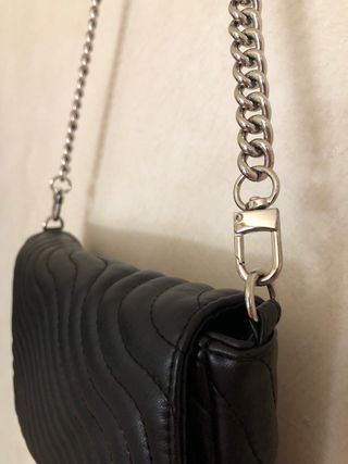 Bolso negro acolchado.

