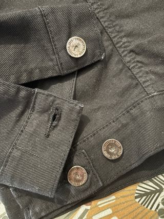 Cazadora Zara Man negra con tachuelas.