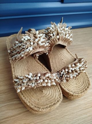 Sandalias planas beige con perlas.