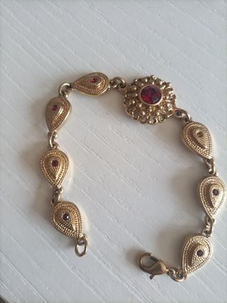 Pulsera dorada con piedras rojas