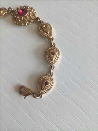 Pulsera dorada con piedras rojas