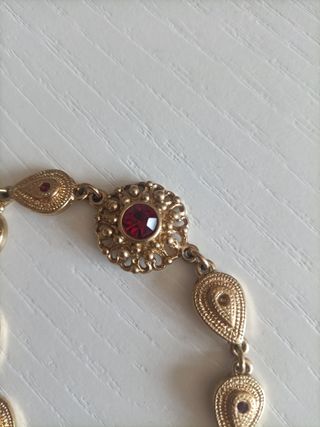 Pulsera dorada con piedras rojas