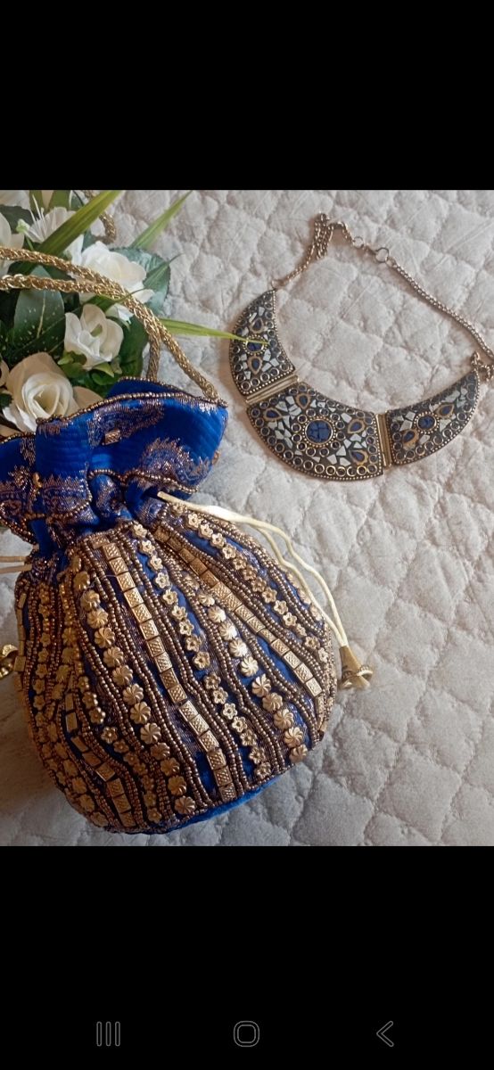 Bolsito azul y collar dorado