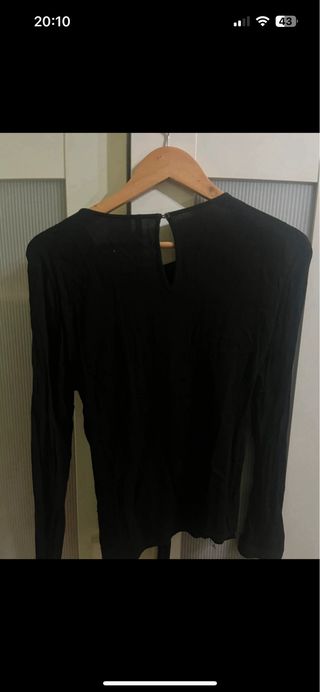 Blusa negra con detalle de hebilla