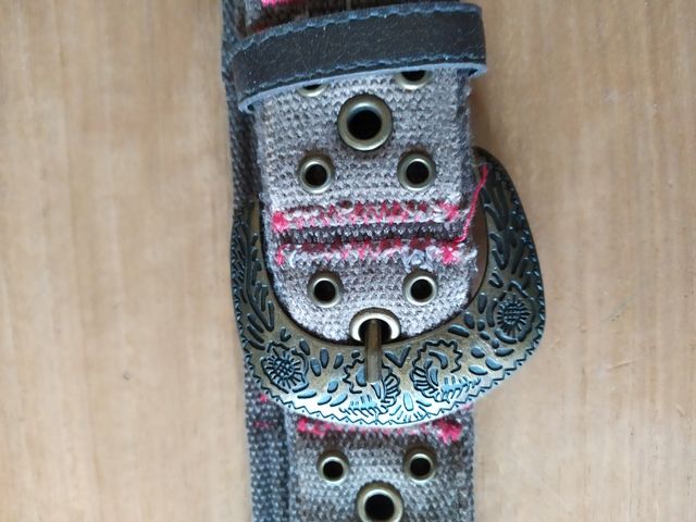 Cintura in tela marrone con cuciture rosse.