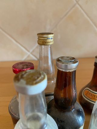 Miniature di bottiglie vuote anni '80 con il loro tappo