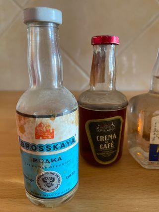 Miniature di bottiglie vuote anni '80 con il loro tappo