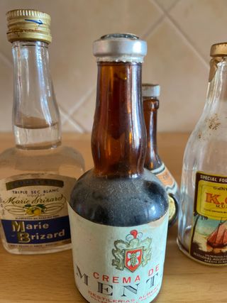 Miniature di bottiglie vuote anni '80 con il loro tappo