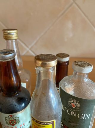 Miniature di bottiglie vuote anni '80 con il loro tappo