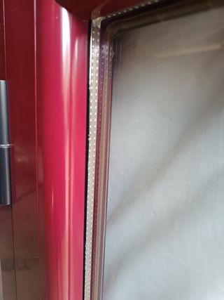 Ventana de aluminio rojo con mosquitera incluida.