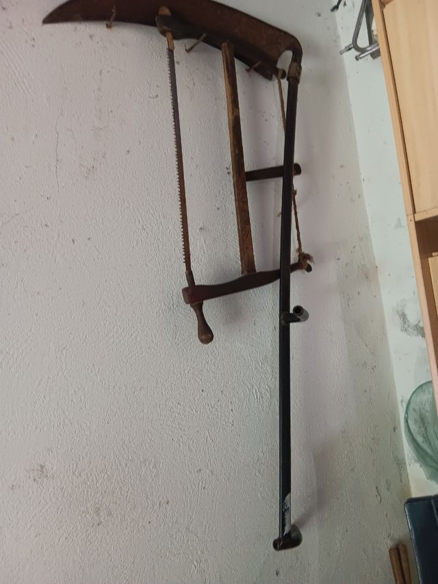 Sierra de mano y guadaña antiguas