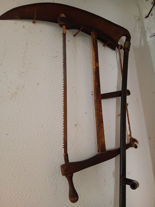 Sierra de mano y guadaña antiguas