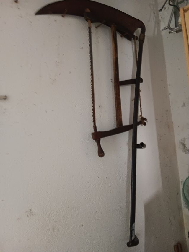 Sierra de mano y guadaña antiguas