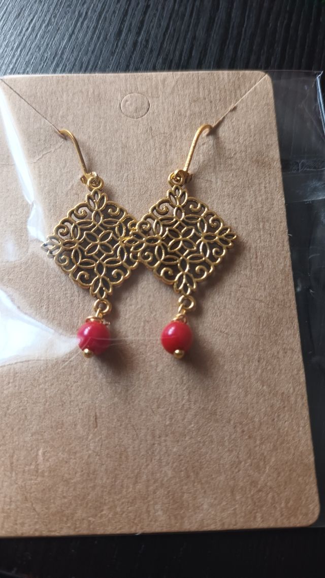 Pendientes dorados con detalles rojos