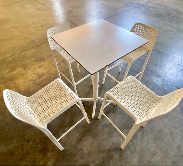 Mesa alta de madera con 4 sillas blancas de pvc