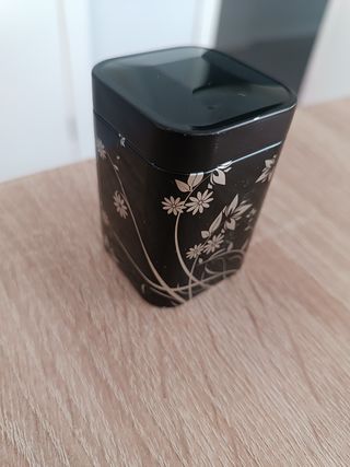 Caja metálica negra con flores