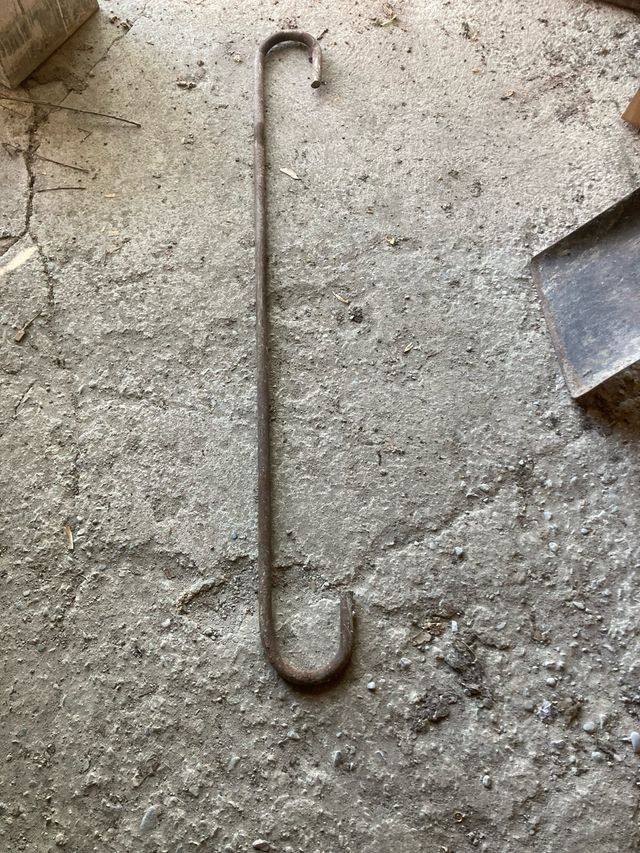 Gancho hierro antiguo y escarpa de gran tamaño