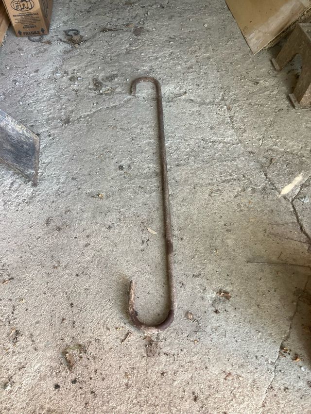 Gancho hierro antiguo y escarpa de gran tamaño