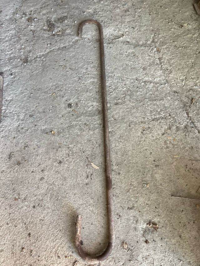 Gancho hierro antiguo y escarpa de gran tamaño