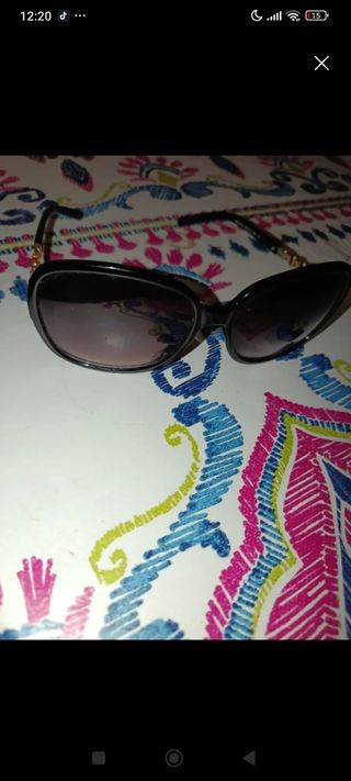 Gafas sol negras doradas