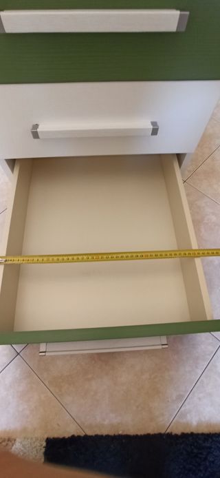 Scrivania angolare bianca e verde con cassettiera.