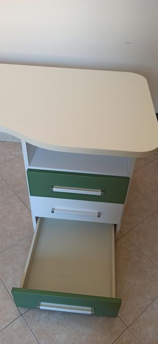 Scrivania angolare bianca e verde con cassettiera.