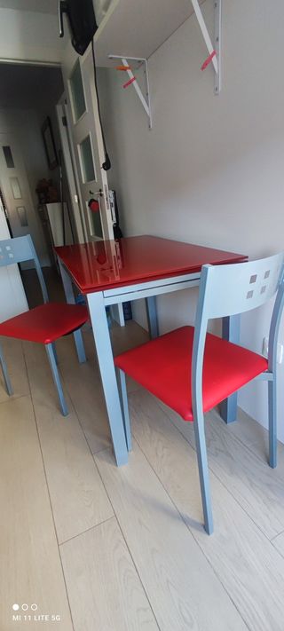 Mesa extensible roja con 2 sillas grises