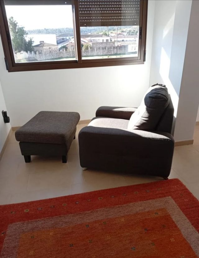 Sillón individual gris-azulado con reposapiés