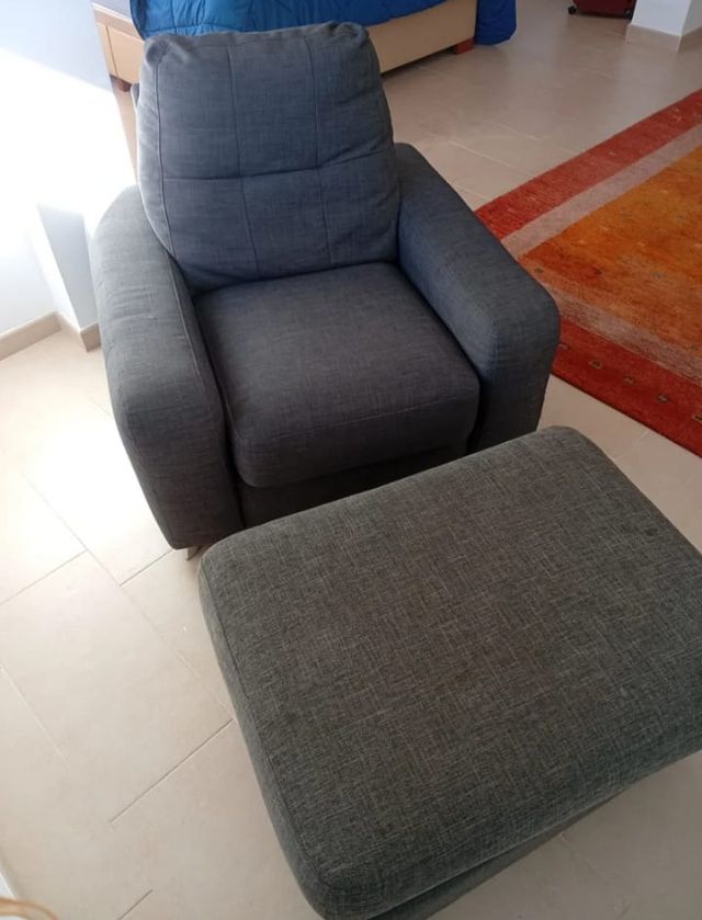 Sillón individual gris-azulado con reposapiés