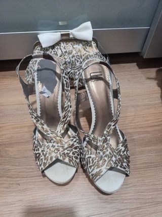 Sandalias y bolso dorados y beige.